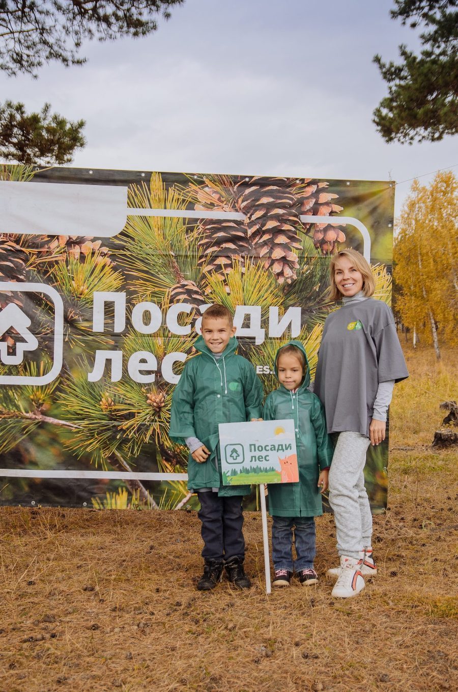 Мама с детьми у баннера «Посади лес»