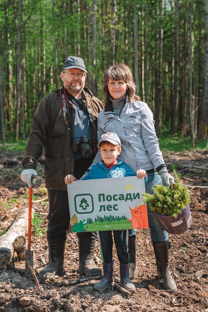 Семья с табличкой «Посади лес» на посадке